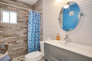 a bathroom with a toilet and a sink and a mirror at Cozy & Beautiful Beachfront Condo Las Olas II 2 in Puerto Peñasco