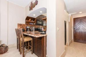 a kitchen with a counter and a bar with chairs at Unique Oceanfront with Epic Sunsets Pinacate 202 in Puerto Peñasco