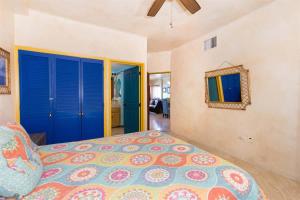 a bedroom with a bed and blue doors and a mirror at Charming Cozy Condo Great View Pinacate 404 in Puerto Peñasco