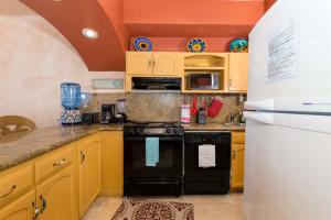 a kitchen with yellow cabinets and a black refrigerator at Charming Cozy Condo Great View Pinacate 404 in Puerto Peñasco +35 photos