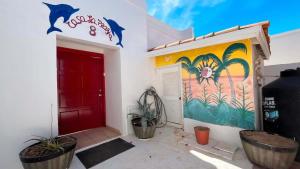 a red door and a wall with a painting on it at Warm & Charming Beachfront Condo Las Olas II 8 in Puerto Peñasco