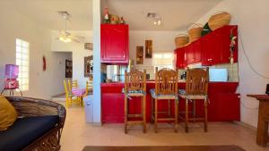 a kitchen with red cabinets and chairs in a room at Warm & Charming Beachfront Condo Las Olas II 8 in Puerto Peñasco