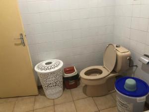 a bathroom with a toilet and a trash can at Chambre indépendante in Port-Gentil +1 photo