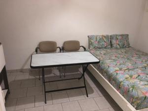 a room with a bed and a table and chairs at Chambre indépendante in Port-Gentil