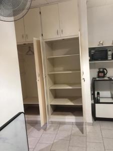 a kitchen with a cupboard and a microwave at Chambre indépendante in Port-Gentil
