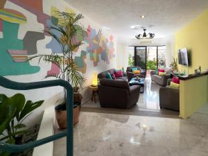 a living room with a colorful mural on the wall at Casa Cuatro Estaciones in Puerto Morelos