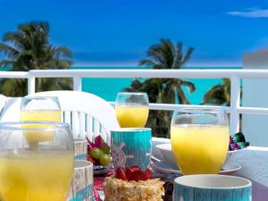 a table with three glasses of orange juice and fruit at Casa Cuatro Estaciones in Puerto Morelos