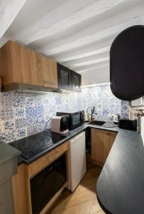 a kitchen with blue and white tiles on the wall at L 'iris, studio Hyper-centre, rue Arcisse de caumont, nouvelle equipe d entretien in Caen