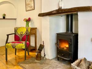 a living room with a wood stove and a chair at Brook House 1 - Uk1415 in Bassenthwaite