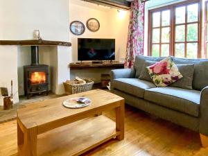 a living room with a couch and a table and a fireplace at Brook House 1 - Uk1415 in Bassenthwaite