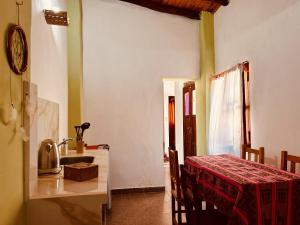 a kitchen and dining room with a table and a sink at Las Pircas Apartamentos - Centro de Cafayate in Cafayate