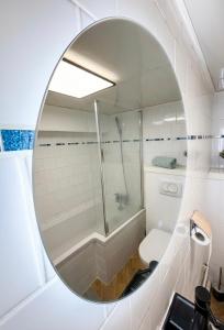 a bathroom with a mirror and a shower and a toilet at L 'iris, studio Hyper-centre, rue Arcisse de caumont, nouvelle equipe d entretien in Caen