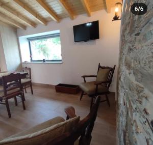 a living room with a couch and a tv on the wall at Casa da Eira in Pinheiro de Coja