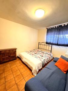 a bedroom with a bed and a couch and a window at Cala Paradiso in Tossa de Mar