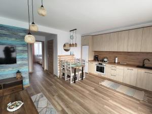 a kitchen with wooden cabinets and a dining room at Apartament Color4you Blue in Wschowa +17 photos