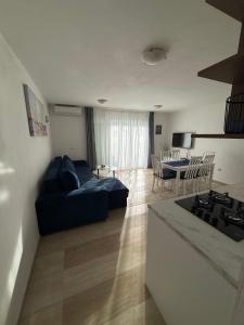 a kitchen and living room with a couch and a table at Apartment Perla in Dinjiška