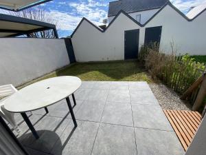 a white table and a bench on a patio at Appartement récent et à la déco moderne in Damgan