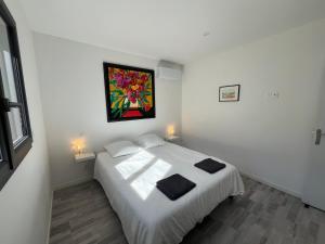 a bedroom with a bed with a painting on the wall at Gîte des Lauriers Blancs in Laurac-en-Vivarais +18 photos