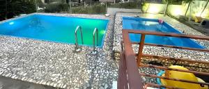 a pool with blue water and rocks around it at Farka Lake Luxury Villa in Tirana
