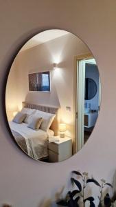 a bedroom with a bed and a round mirror at EOS Suite Apartment - a due passi da Piazza Pisanelli e Ospedale Panico in Tricase