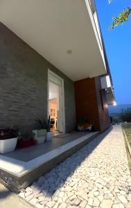 a house with a stone walkway leading to a door at Farka Lake Luxury Villa in Tirana