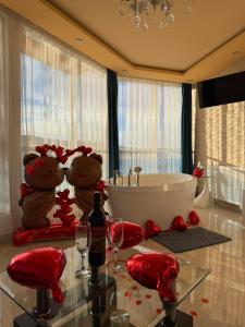 a bathroom with a tub and a glass table with wine glasses at Safi in Dospat
