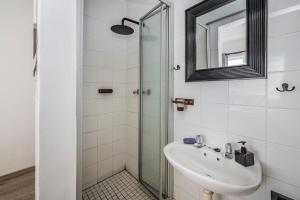 a bathroom with a sink and a glass shower at Namclassics in Langstrand +42 photos