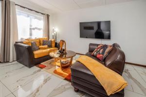 a living room with two couches and a tv at Namclassics in Langstrand