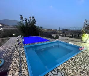 a blue swimming pool on the roof of a house at Farka Lake Luxury Villa in Tirana