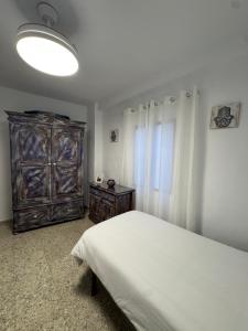 a bedroom with a bed and a wooden dresser at Mil House in Cómpeta