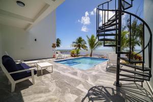 a house with a swimming pool and a spiral staircase at Villa Armoniosa Spacious Beachfront 2BR with Pool - Lower Level in Placencia