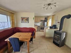 a living room with a couch and a table and a stove at Haus am Waldesrand in Wustrow
