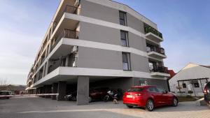 a red car parked in front of a building at Timeless Comfort in Sfântu-Gheorghe +7 photos