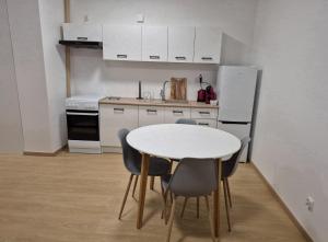 a kitchen with a table and chairs and a refrigerator at Włocławek Saperska in Włocławek
