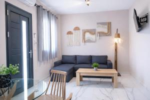a living room with a blue couch and a table at GreKa apartments in Kalives Poligirou