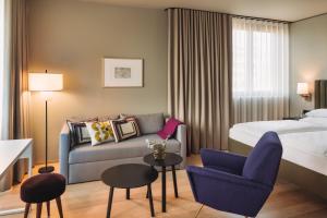 a hotel room with a bed and a couch at Hotel am See in Hard +65 photos