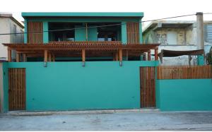 a blue building with a gate and a fence at Casa Cayito Agua Dulce in Arecibo