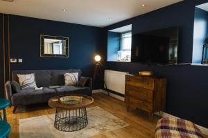 a living room with a couch and a table at Snowdon Studio Apartment in Colwyn Bay