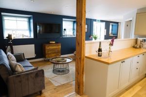 a kitchen and living room with a couch and a table at Snowdon Studio Apartment in Colwyn Bay +10 photos