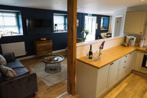 a kitchen and living room with a couch and a table at Snowdon Studio Apartment in Colwyn Bay