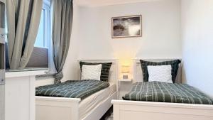 two beds in a small room with windows at Dat Lütte Glück in Pruchten