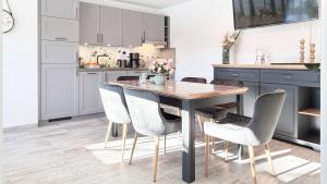 a kitchen with a wooden table and chairs at Dat Lütte Glück in Pruchten