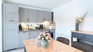 a kitchen with a table with a vase of flowers on it at Dat Lütte Glück in Pruchten