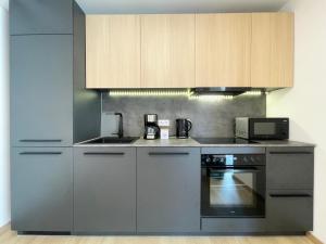 a kitchen with stainless steel appliances and wooden cabinets at Schönes Apartment Traumblick mit Balkon Bad Ems in Bad Ems