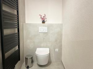 a bathroom with a toilet and a vase of flowers at Schönes Apartment Traumblick mit Balkon Bad Ems in Bad Ems +10 photos