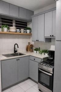 a kitchen with white cabinets and a sink and a stove at The Oxford Suite in Kingston