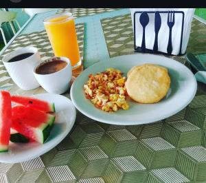 a table with two plates of food and fruit on it at Hotel King Versalles in Cali
