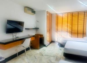 a bedroom with a bed and a desk and a tv at Hotel King Versalles in Cali
