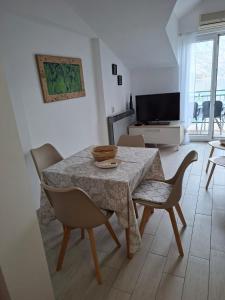 a living room with a table and chairs and a television at Apartments Iva in Kotor