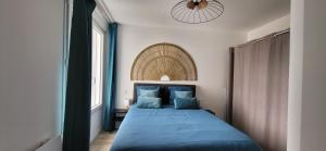 a bedroom with a blue bed and a window at L'écume du fort , Face à la mer, Coucher de soleil in Le Portel